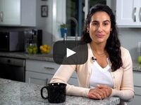 Woman sitting in kitchen with coffee cup